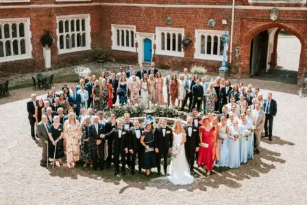 An areal photo of a wedding party standing in a circle