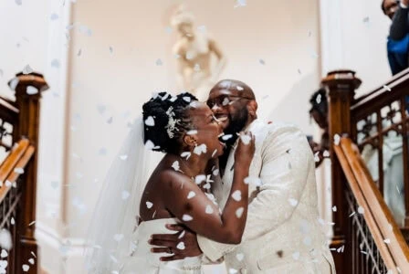 A newly wed couple kissing on a set of stairs